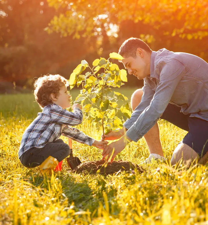 man and little boy planting a tree