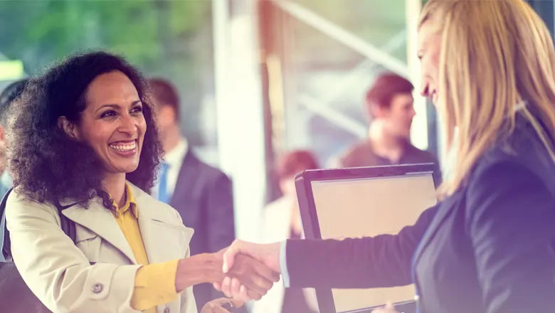 smiling women shaking hands